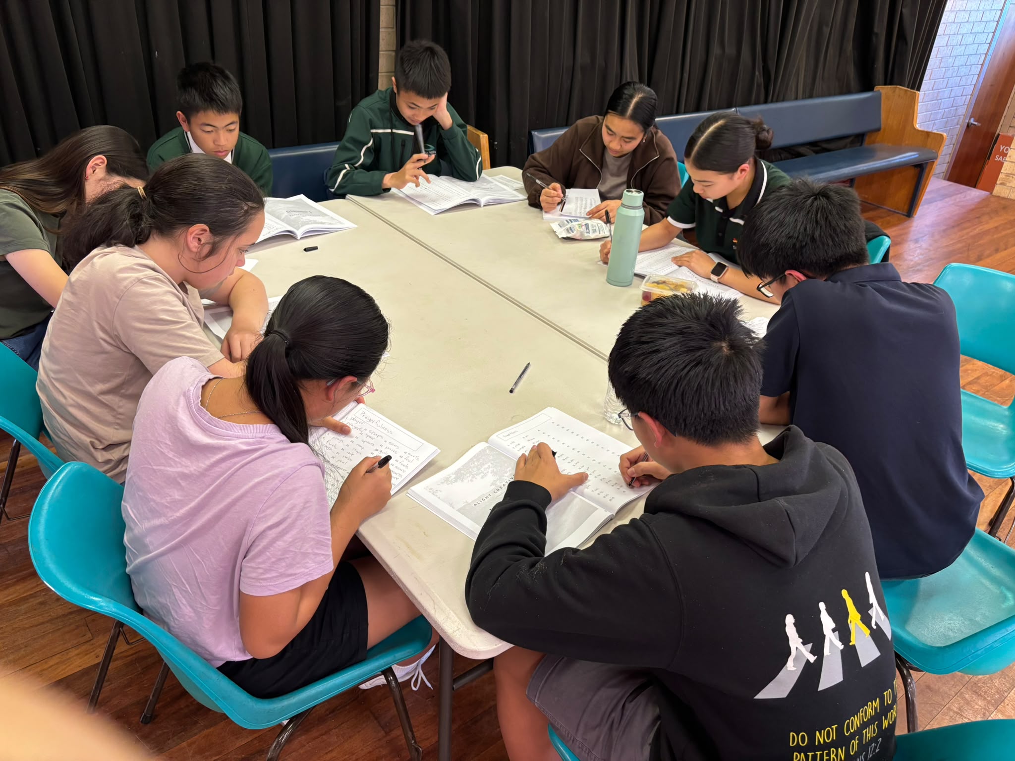 Alight Creative students writing together around a table in class